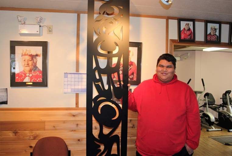 Walter Brown holds a room divider he designed and carved, which will be featured in all 85 rooms at Kwa’lilas Hotel.