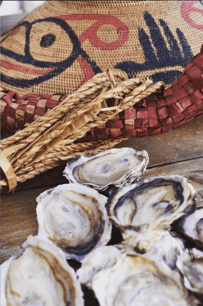 shucked oysters sitting in front of a traditional cedar woven hat.
